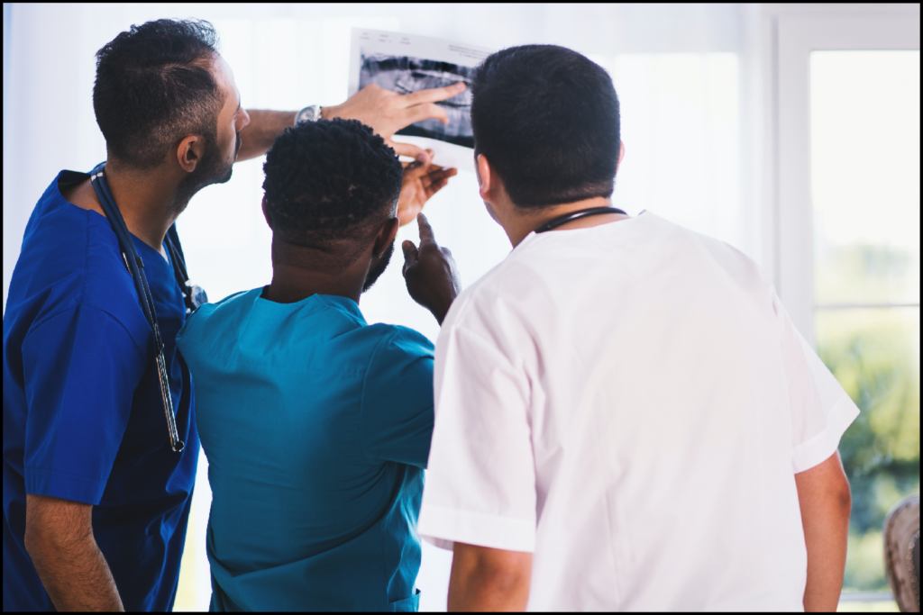 Three medical professionals looking at a scan